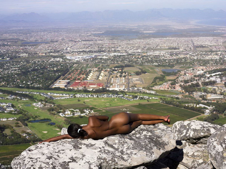 чернокожая лежит на камнях